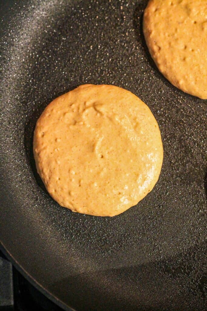 Raw pancake batter in a skillet.