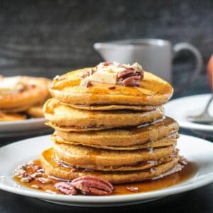 Stack of fluffy pancakes drizzled with maple syrup.