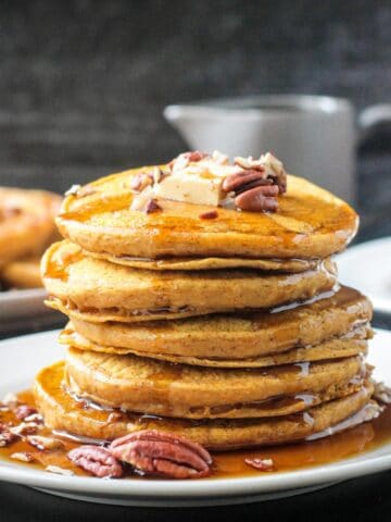 Stack of fluffy pancakes drizzled with maple syrup.