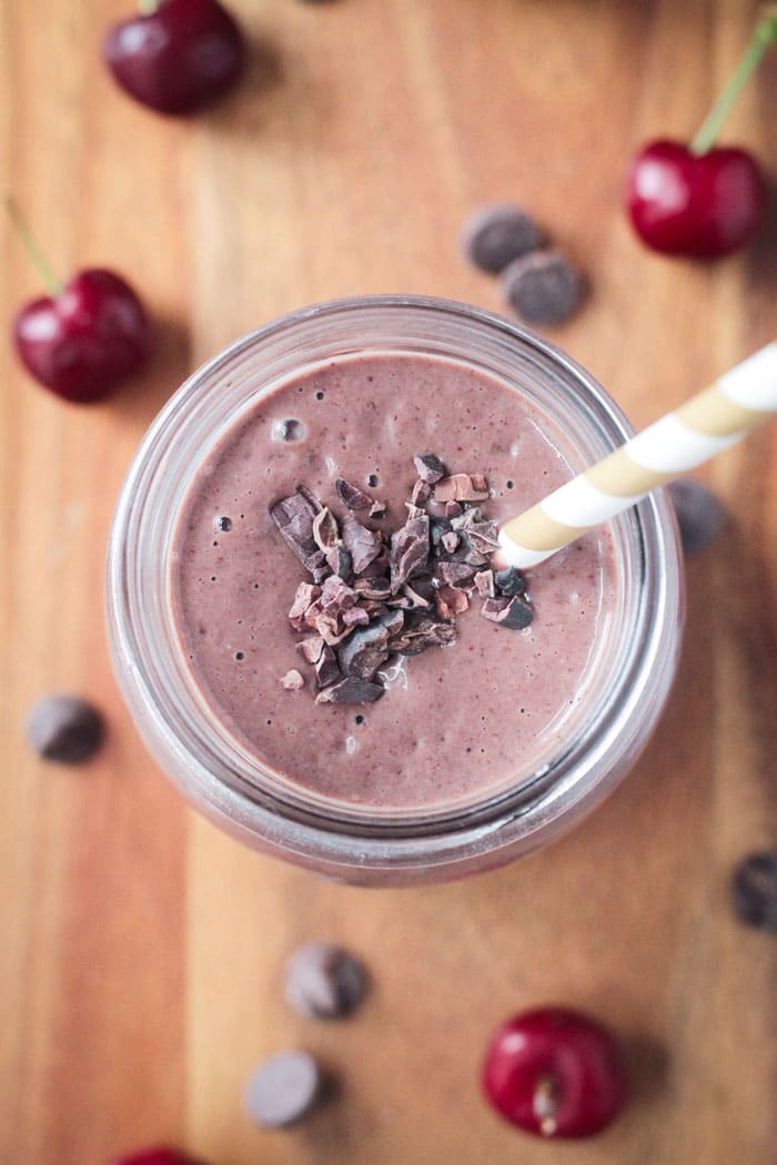 Chocolate Covered Cherry Smoothie - Healthy enough for breakfast, indulgent enough for dessert. Tastes like a milkshake! Bonus: It's quick and easy. Only 5 ingredients and a few short minutes is all you need to make this delicious dairy free, thick creamy drink. Top of a creamy pink smoothie garnished with cocoa nibs.