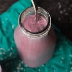 Coconut Berry Smoothie in a glass with a reusable straw.