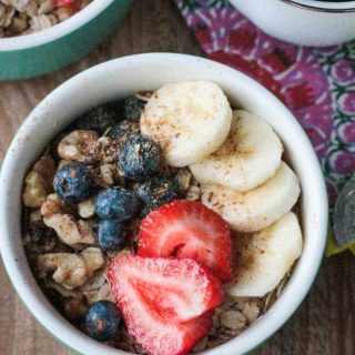 bowl of oat and nuts topped with fresh fruit
