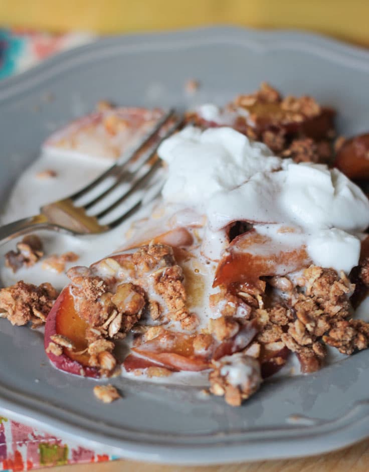 Whipped coconut cream topping over peaches and oat crumble.