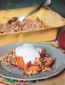 peach crisp on a gray plate topped with whipped cream