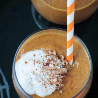 overhead view of a pumpkin smoothie topped with whipped cream and chopped pecans