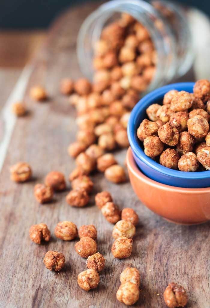 Smoky Roasted Chickpeas sprinkled about on a wooden board.