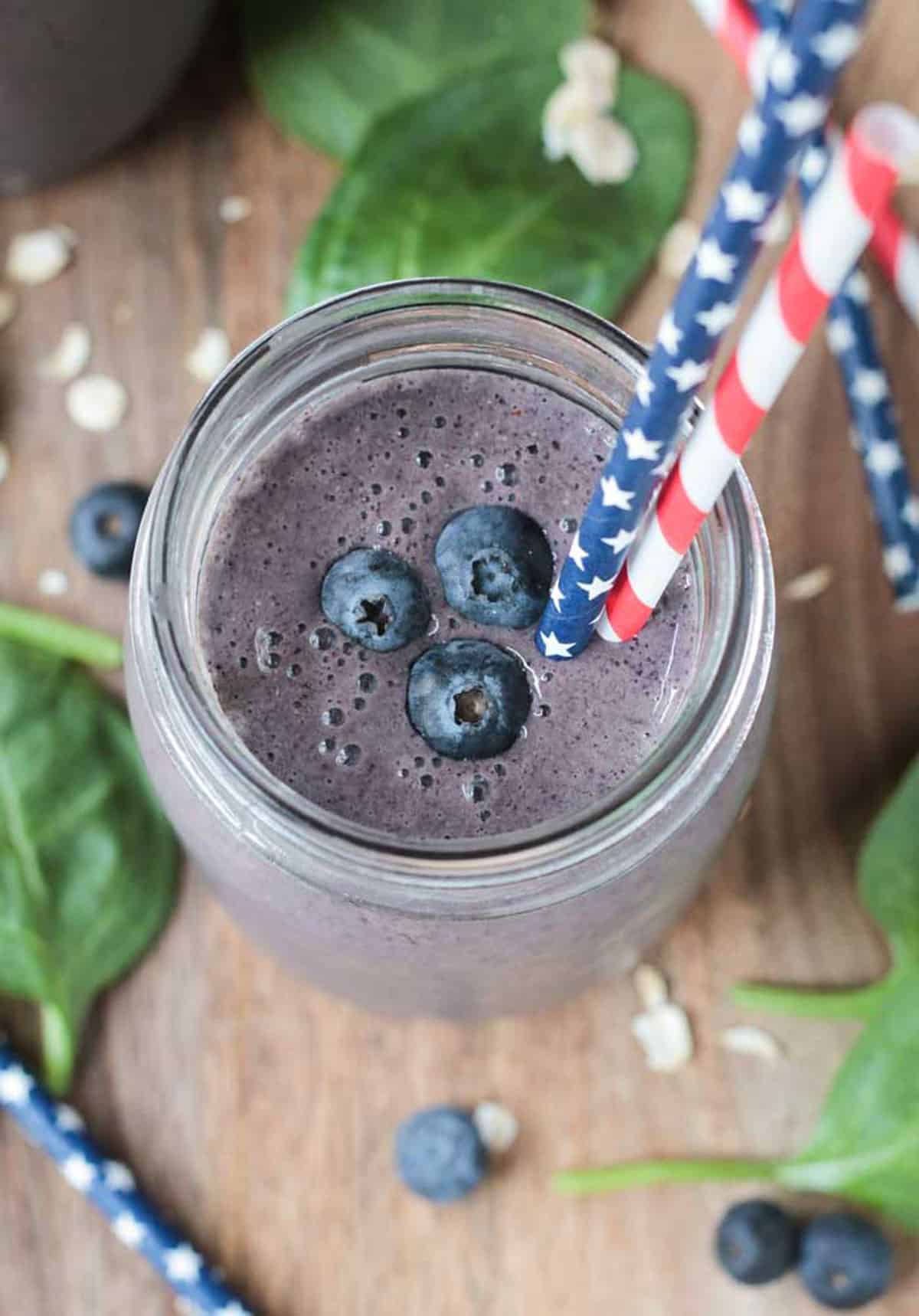 Overhead view of a blueberry smoothie with 3 fresh blueberries on top.