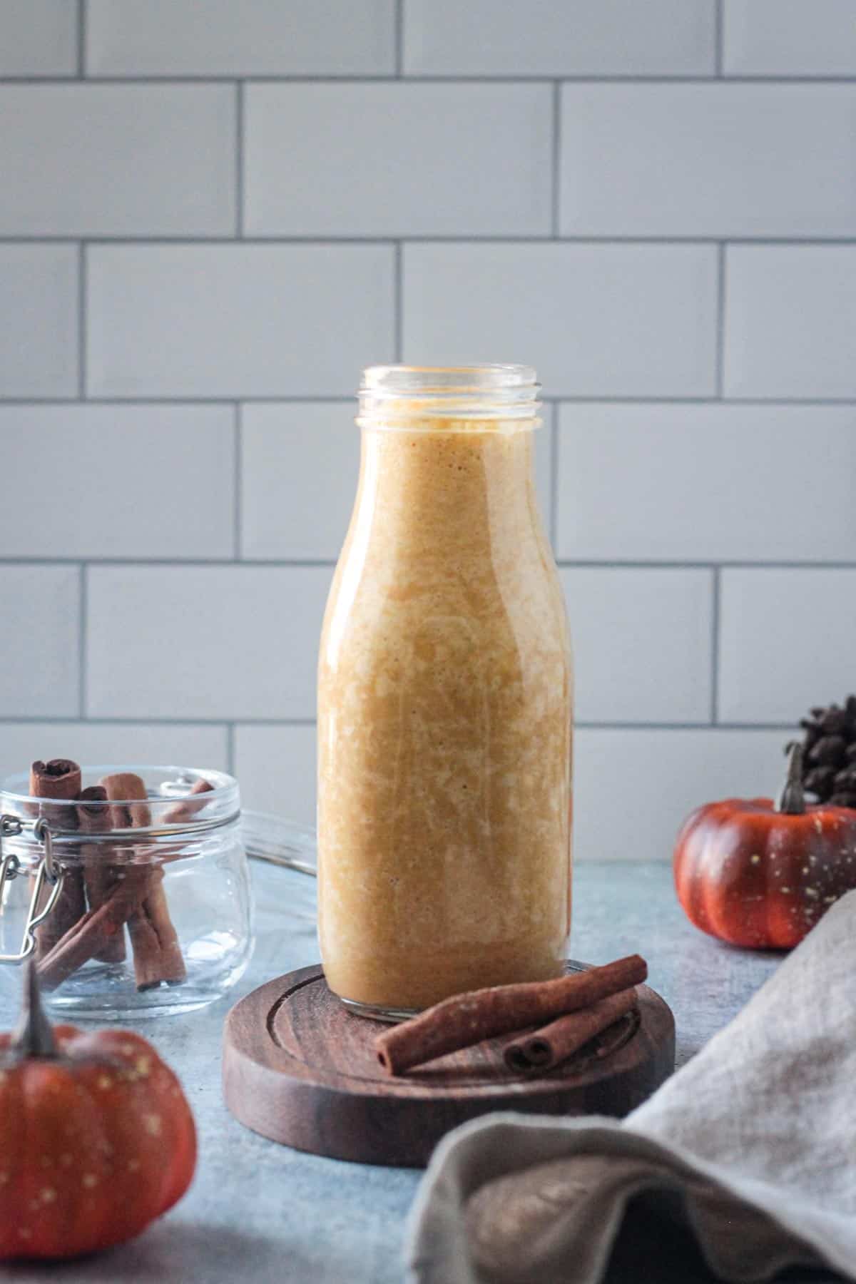 Dairy-free pumpkin spice creamer in a glass bottle.