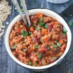 Pot of vegan pumpkin chili with two spoons.