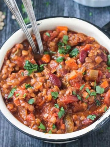 Pot of vegan pumpkin chili with two spoons.