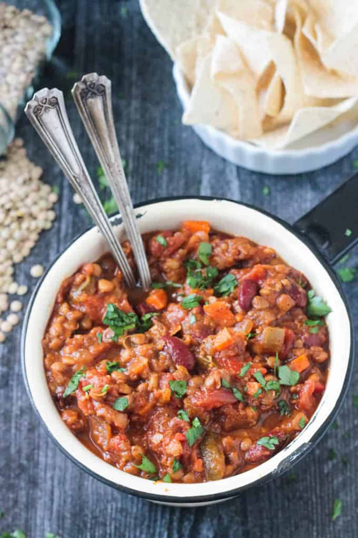 Pot of vegan pumpkin chili with two spoons.