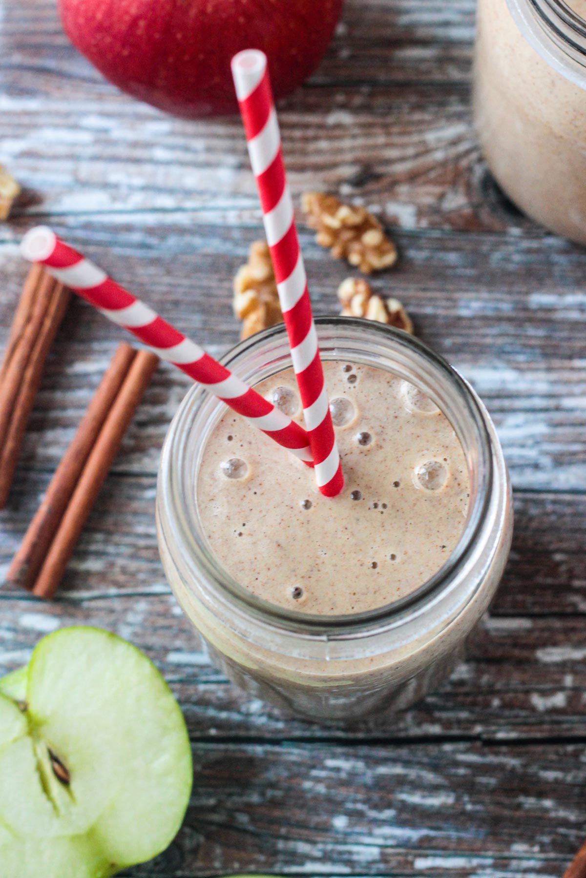 Two tall red and white striped straws in an apple pie smoothi.
