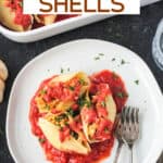 Three vegan stuffed shells on a plate with two forks.