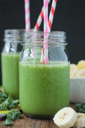 two glass jars with green smoothies