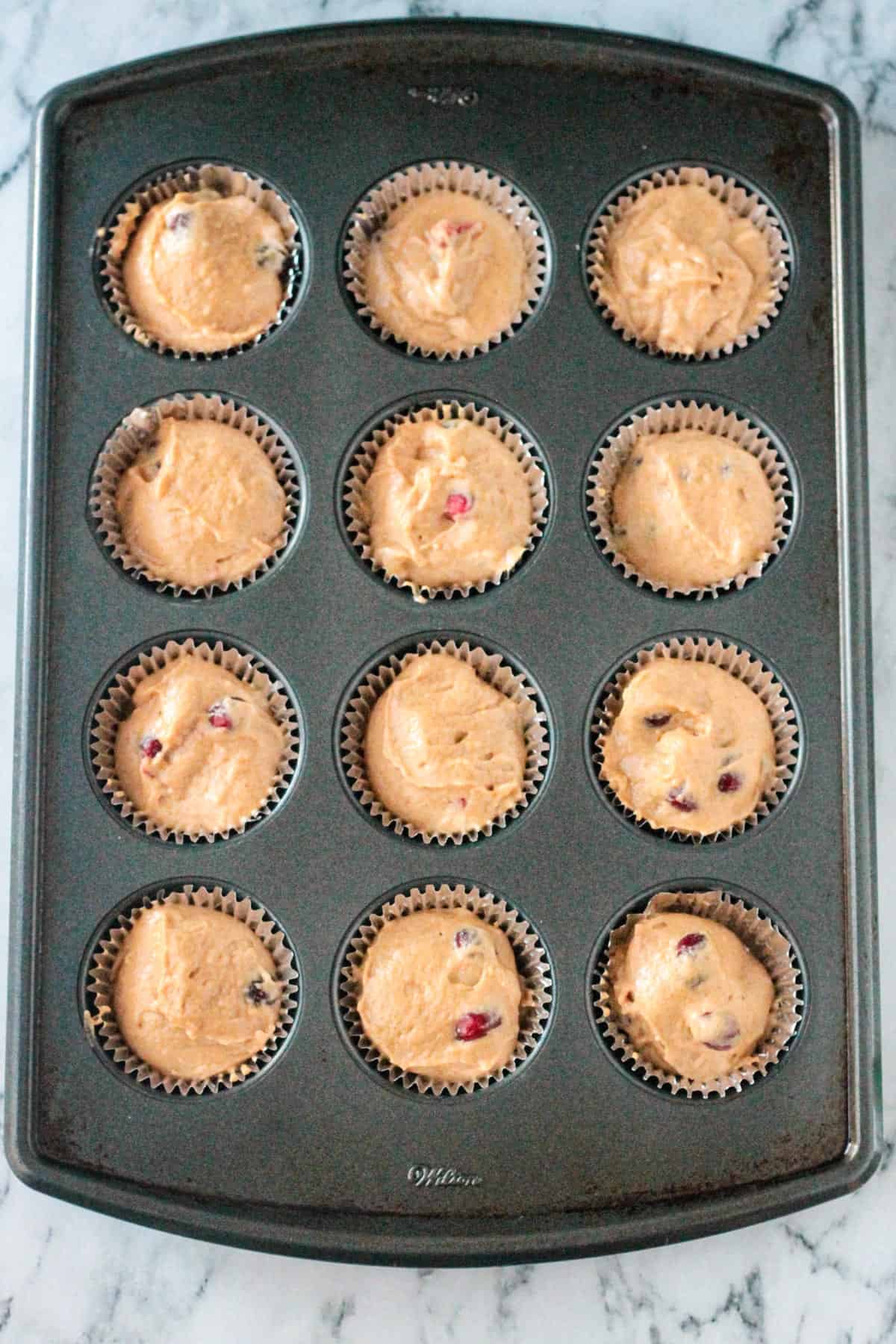 Muffin tin filled with batter.