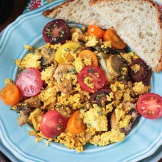 tofu scramble with mushrooms and tomatoes on a blue plate