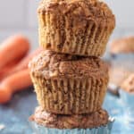 Three vegan carrot muffins stacked on top of each other.