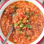 Metal spoon in a bowl of vegan stuffed pepper soup.