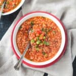 Metal spoon in a bowl of vegan stuffed pepper soup.