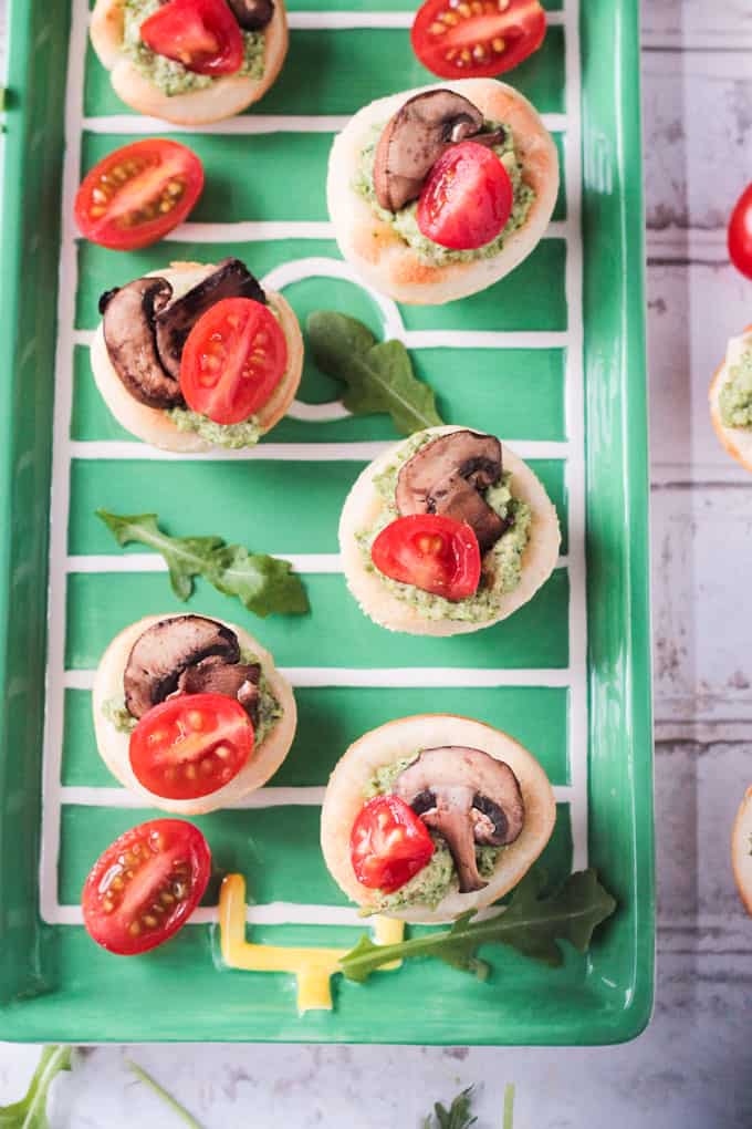 Overhead view Vegan Pizza Bites on a green tray.