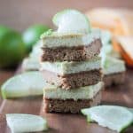 Stack of three vegan lime bars on a wooden tray.