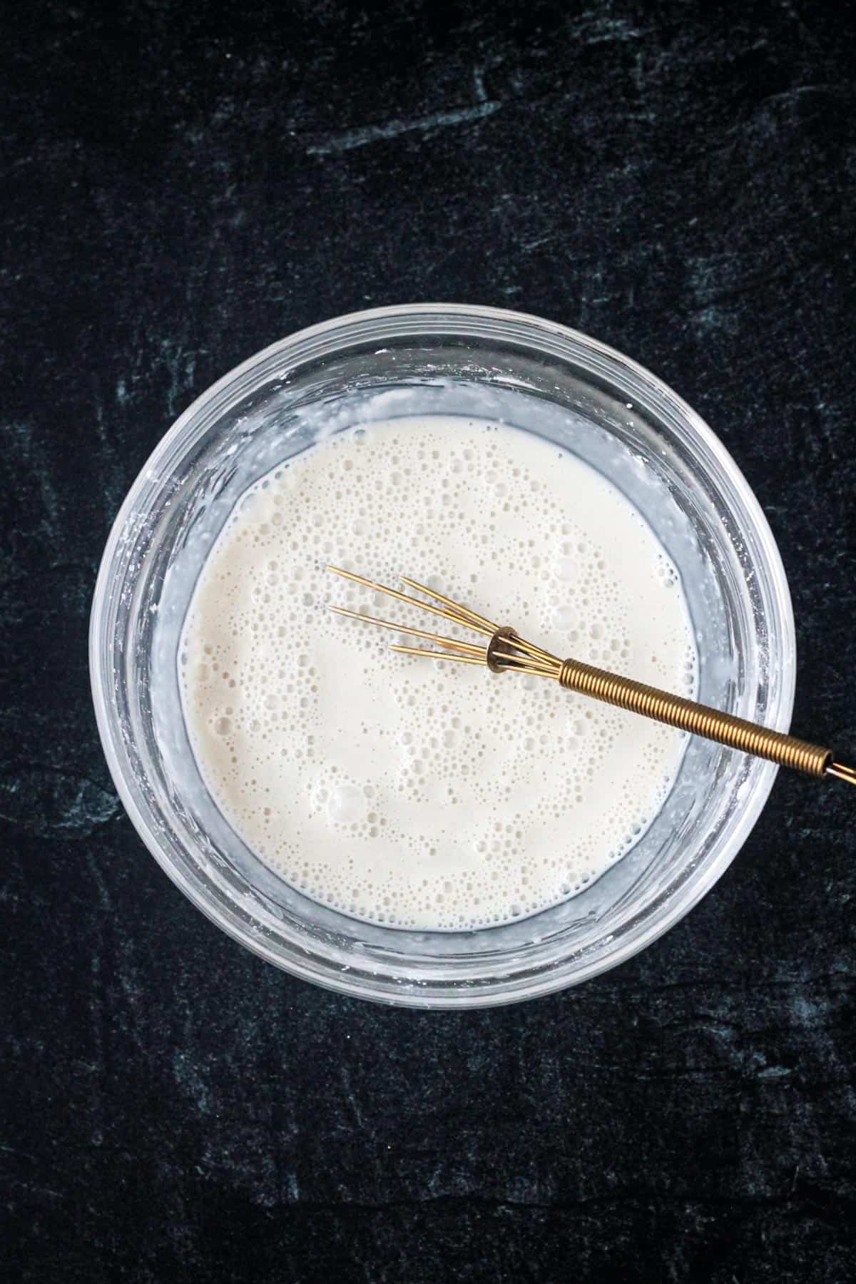 Cornstarch and milk whisked together in a bowl.