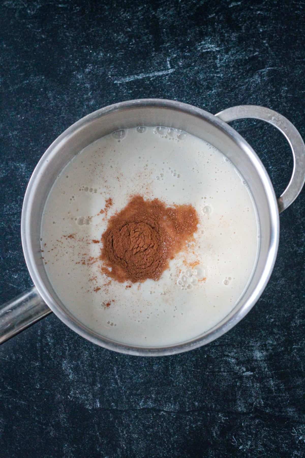 Milk and spices in a sauce pot.