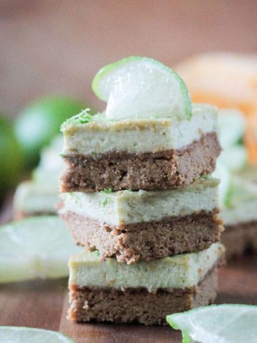 Stack of three vegan lime bars on a wooden tray.