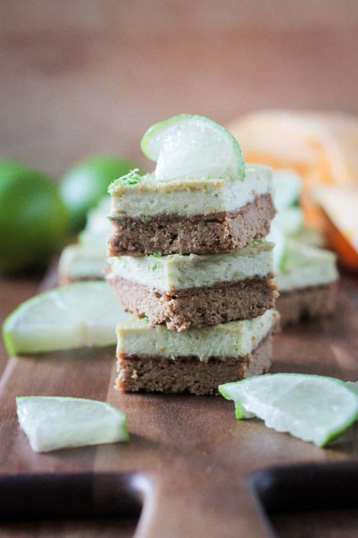 Stack of three vegan lime bars on a wooden tray.