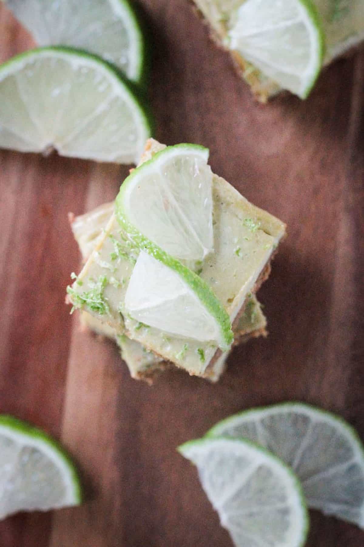 Close up of a twisted lime wedge on top of a dessert bar.
