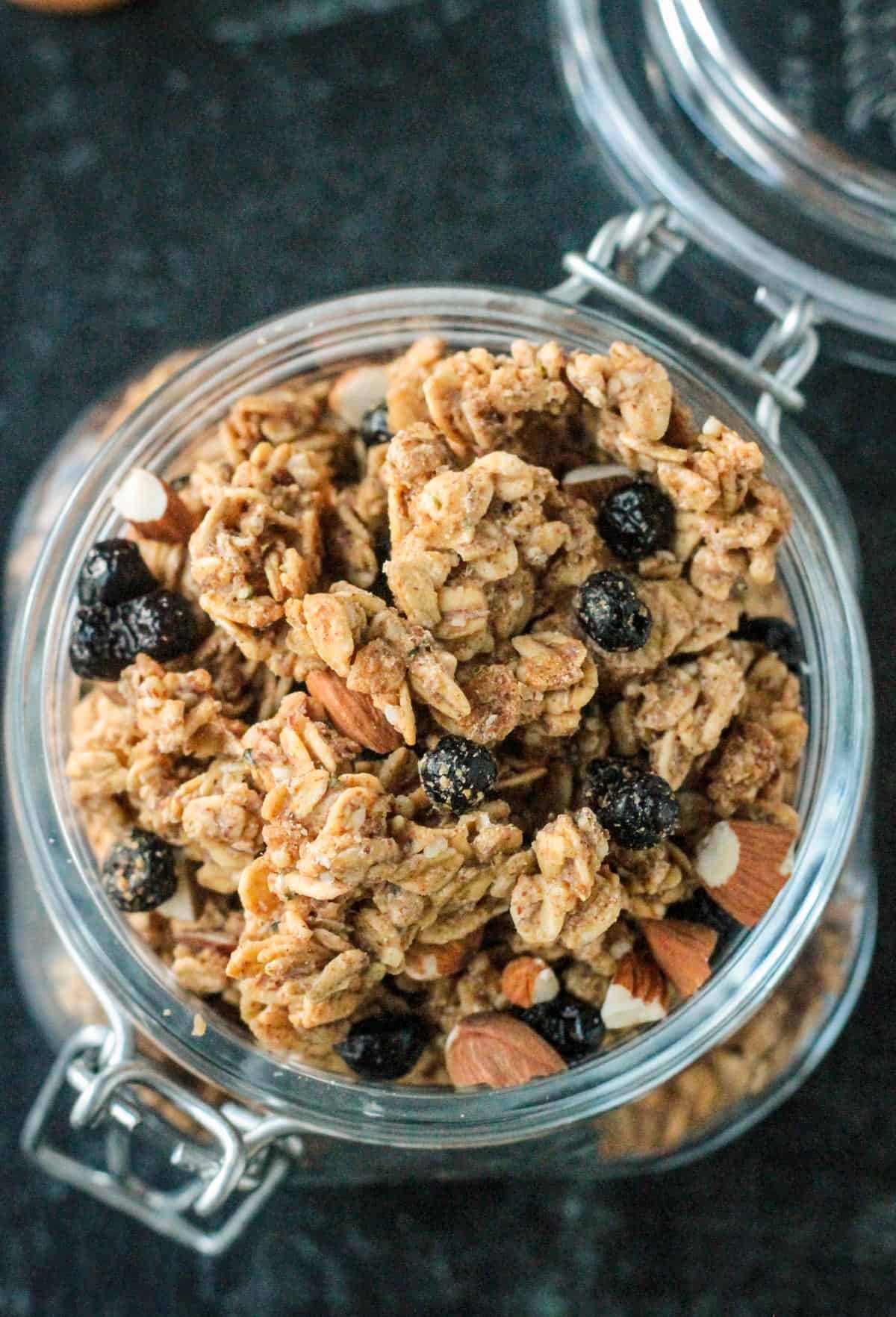 Overhead view of chunky granola clusters in an open mason jar.