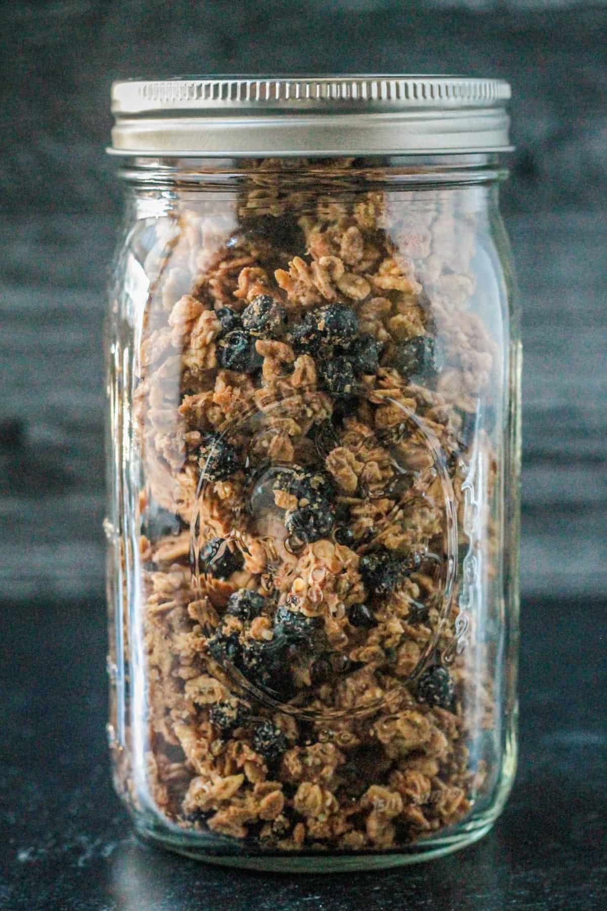 Front view of blueberry almond granola in a glass jar.