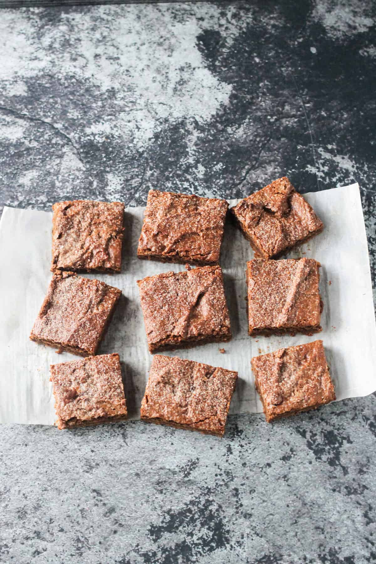 Finished recipe cut into 9 squares on a piece of parchment paper.