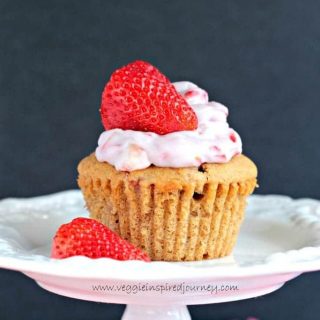 cupcake topped with frosting and a fresh strawberry