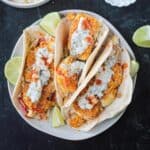 Three breaded cauliflower tacos on a plate.