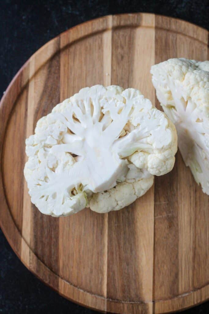 Half of a cauliflower on a cutting board.