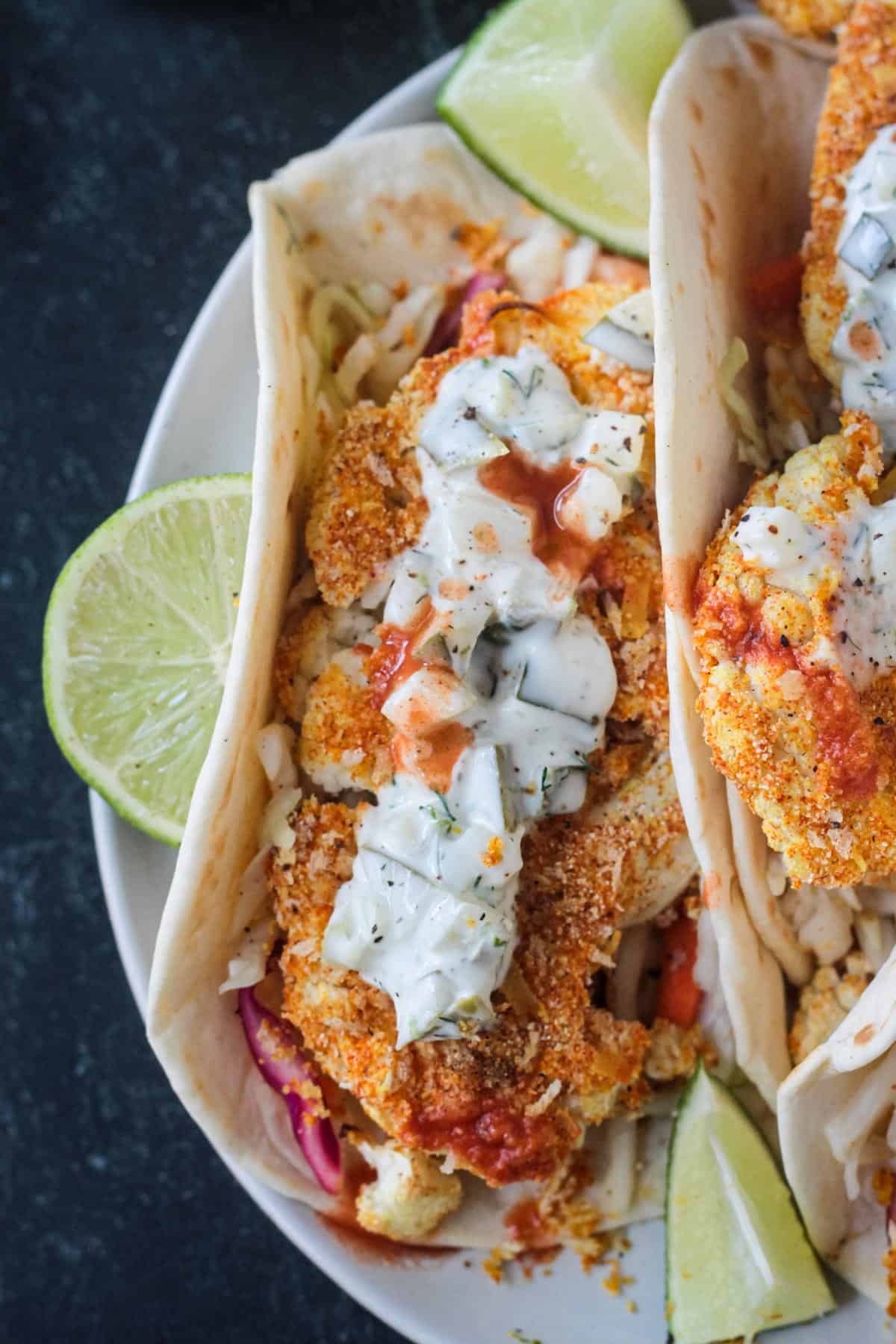 Close up of a crispy breaded piece of cauliflower in a tortilla.