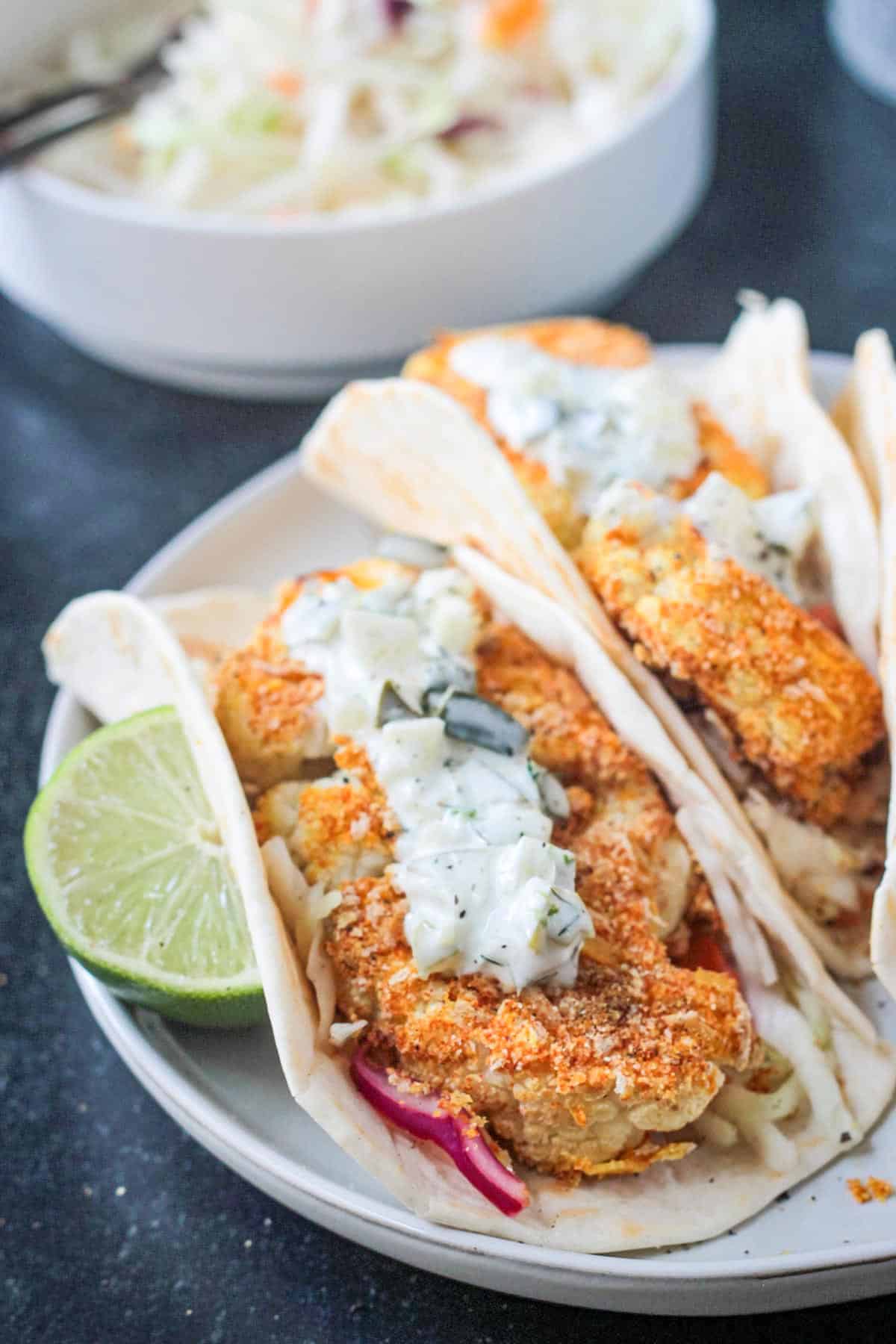 Crispy breaded cauliflower pieces wrapped in a tortilla and topped with tartar sauce.