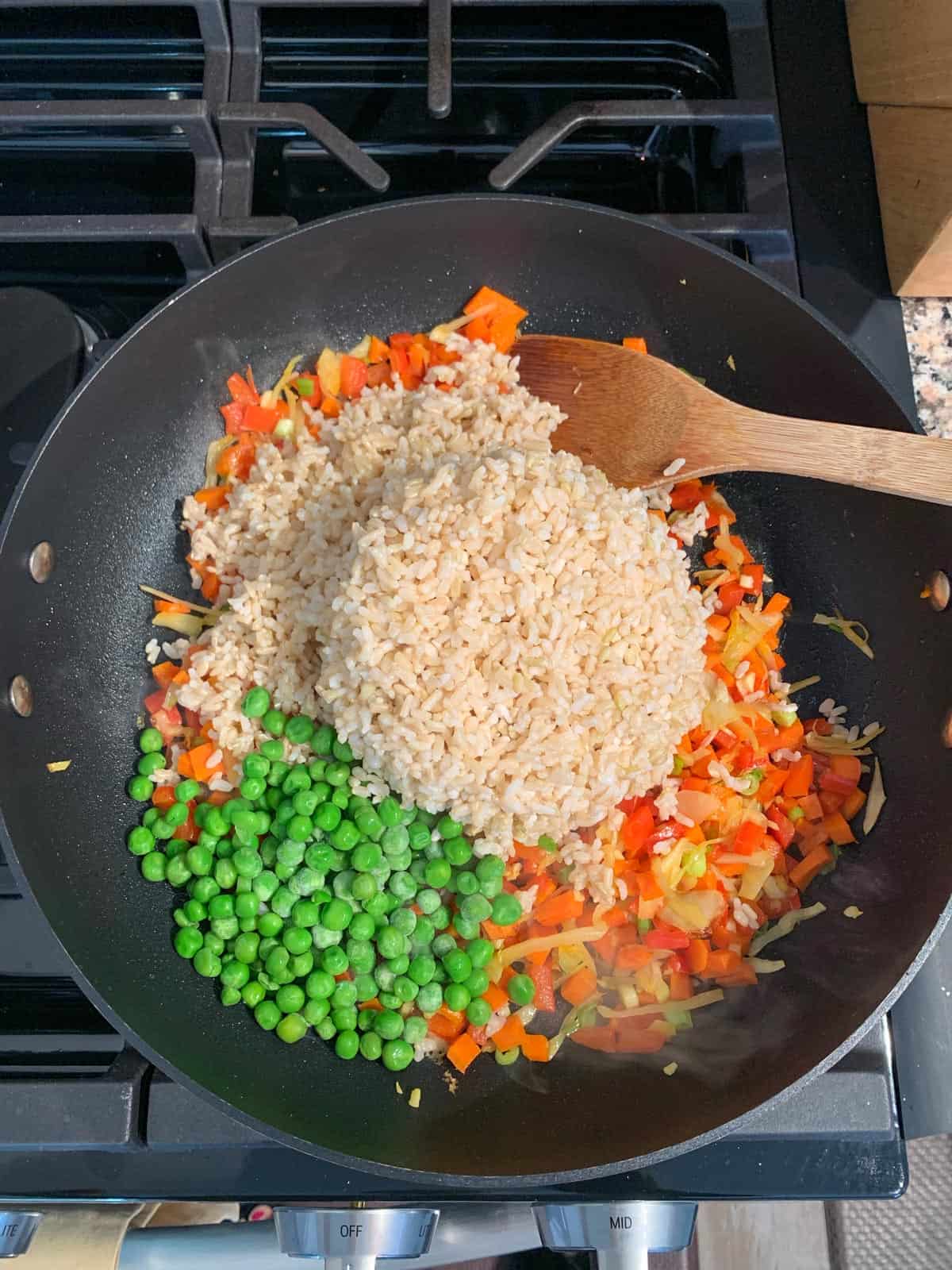 Adding rice, peas, and sauce to the skillet.