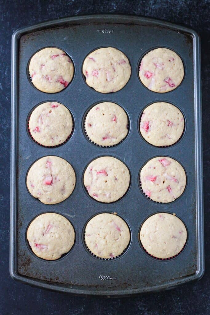 Baked strawberry cupcakes in a cupcake pan.