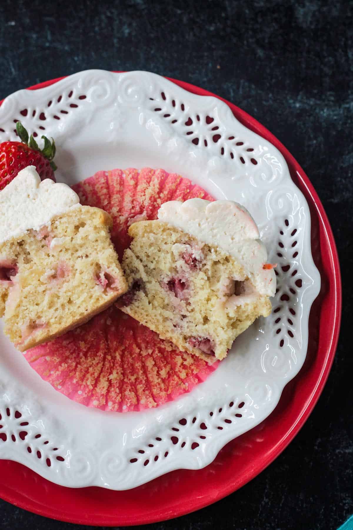 One baked cupcake cut in half on a plate.