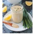 A wooden spoon covered in southwest ranch dressing in front a jar full of more dressing