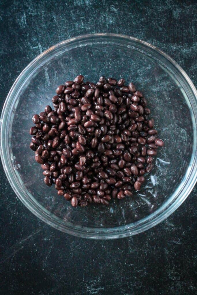 Black beans in a glass mixing bowl.