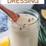 Small wooden spoon in a j ar of vegan ranch dressing.