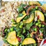 Spring vegetable quinoa on a plate with two forks.