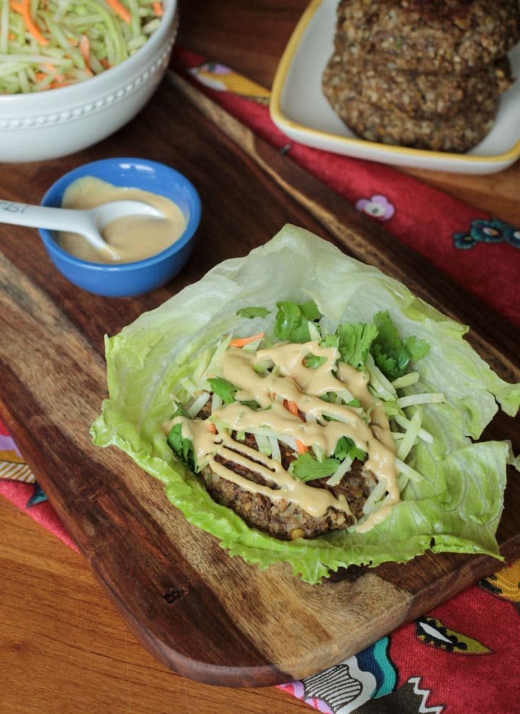 Sesame salad dressing drizzled over a lentil burger in a lettuce wrap.