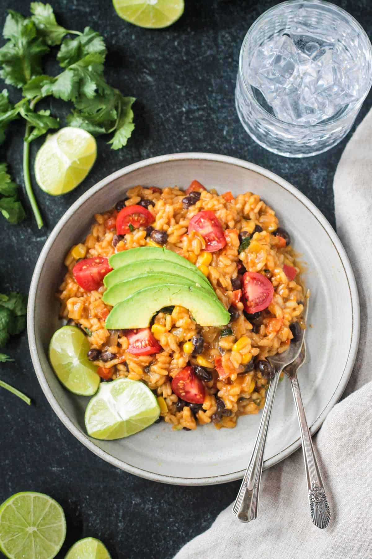 Serving of vegan Mexican risotto topped with sliced avocado on a plate.