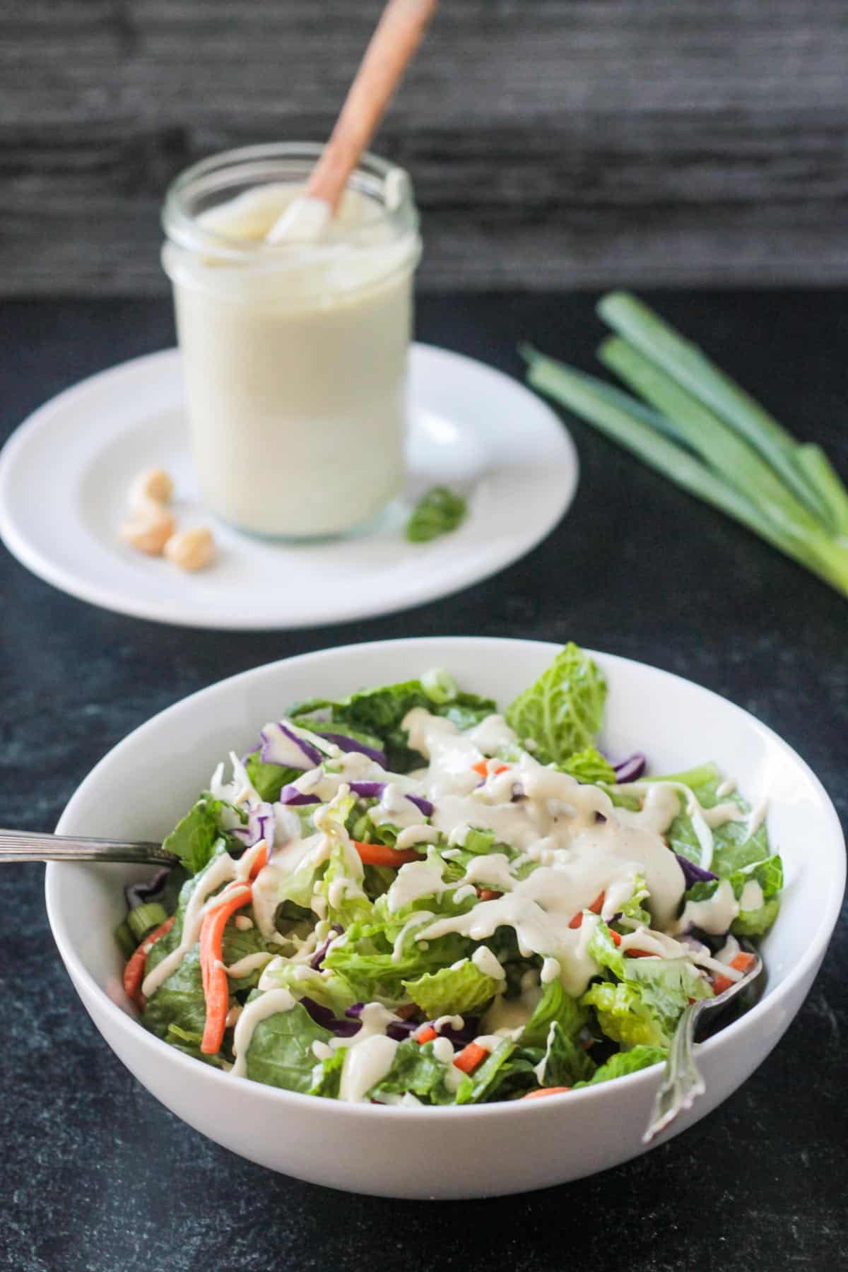 Fork in a salad bowl topped with sesame salad dressing.