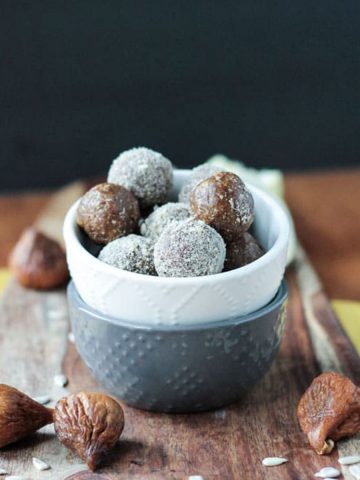 Sunflower Fig Balls in a white bowl with dried figs scattered about.