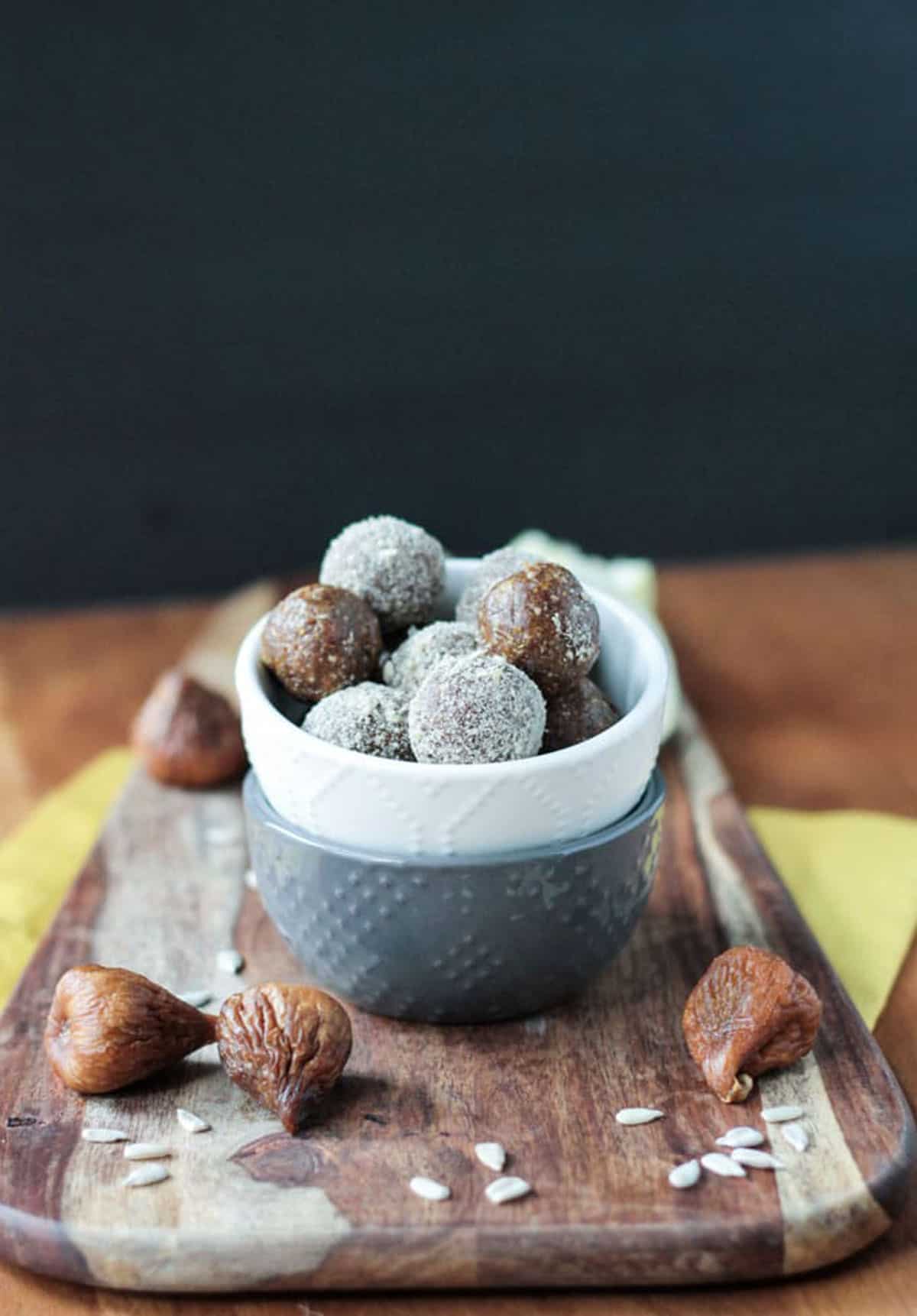 Sunflower Fig Balls in a white bowl with dried figs scattered about.